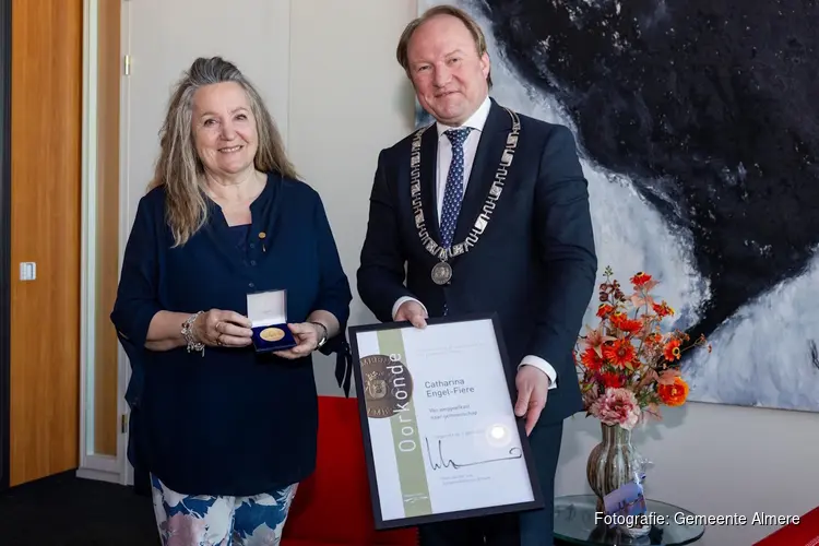 Carin Fiere heeft de Erepenning van de gemeente Almere ontvangen uit handen van burgemeester Hein van der Loo